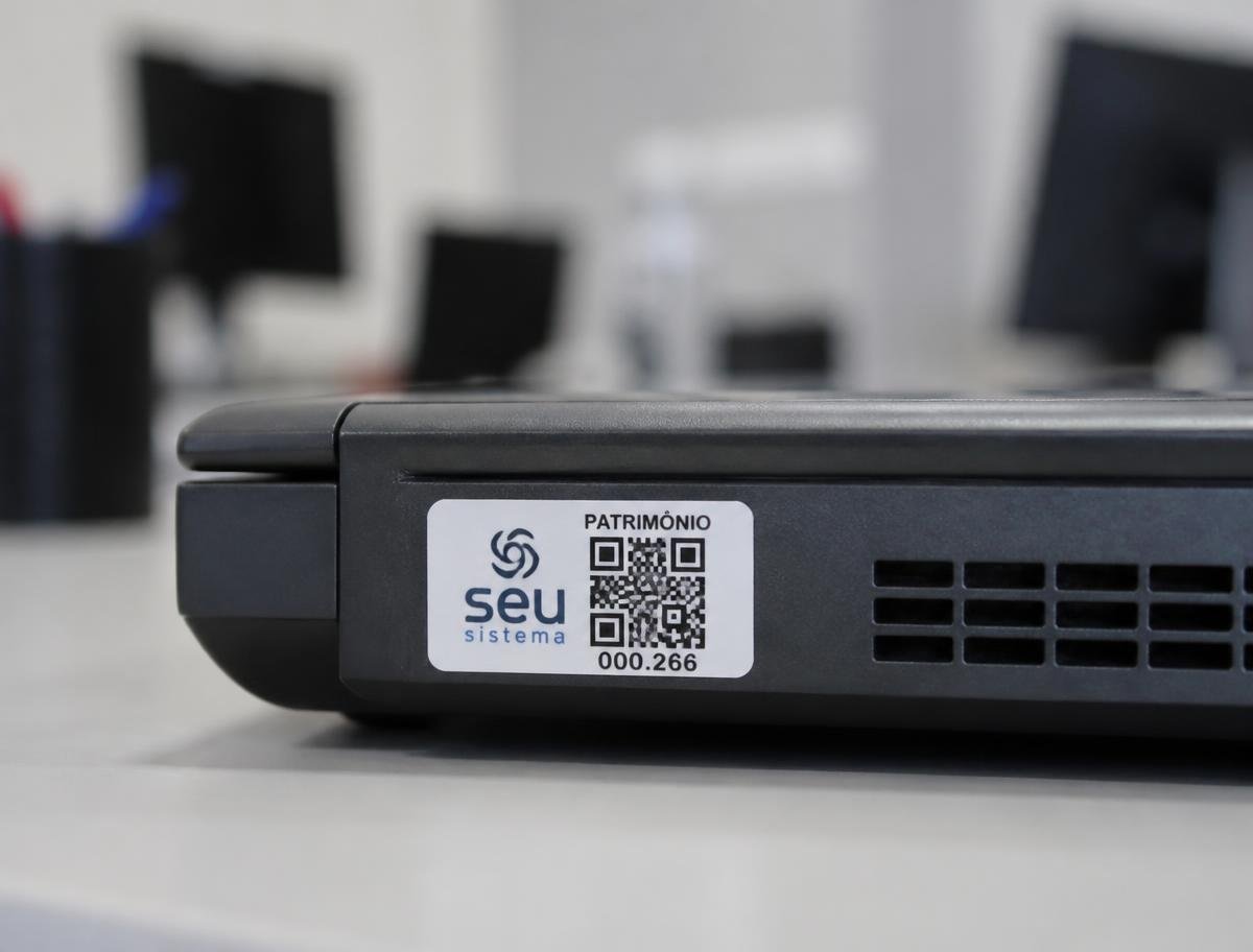 Etiqueta de patrimônio com QR Code colada em um notebook corporativo